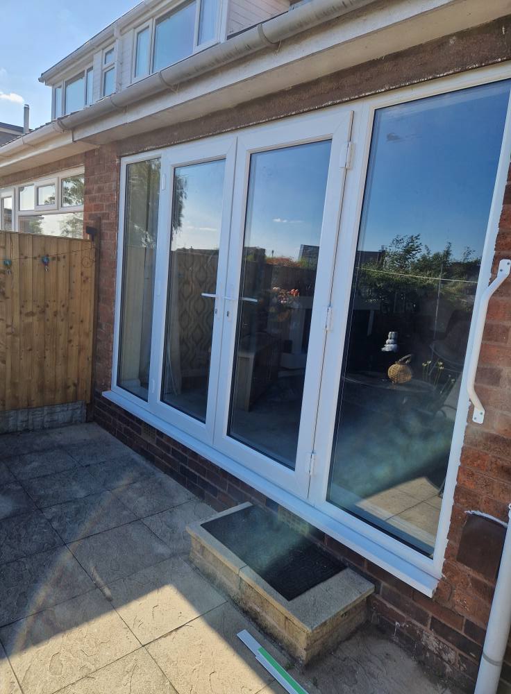 White UPVC bifold patio doors installed on brick house in Staffordshire